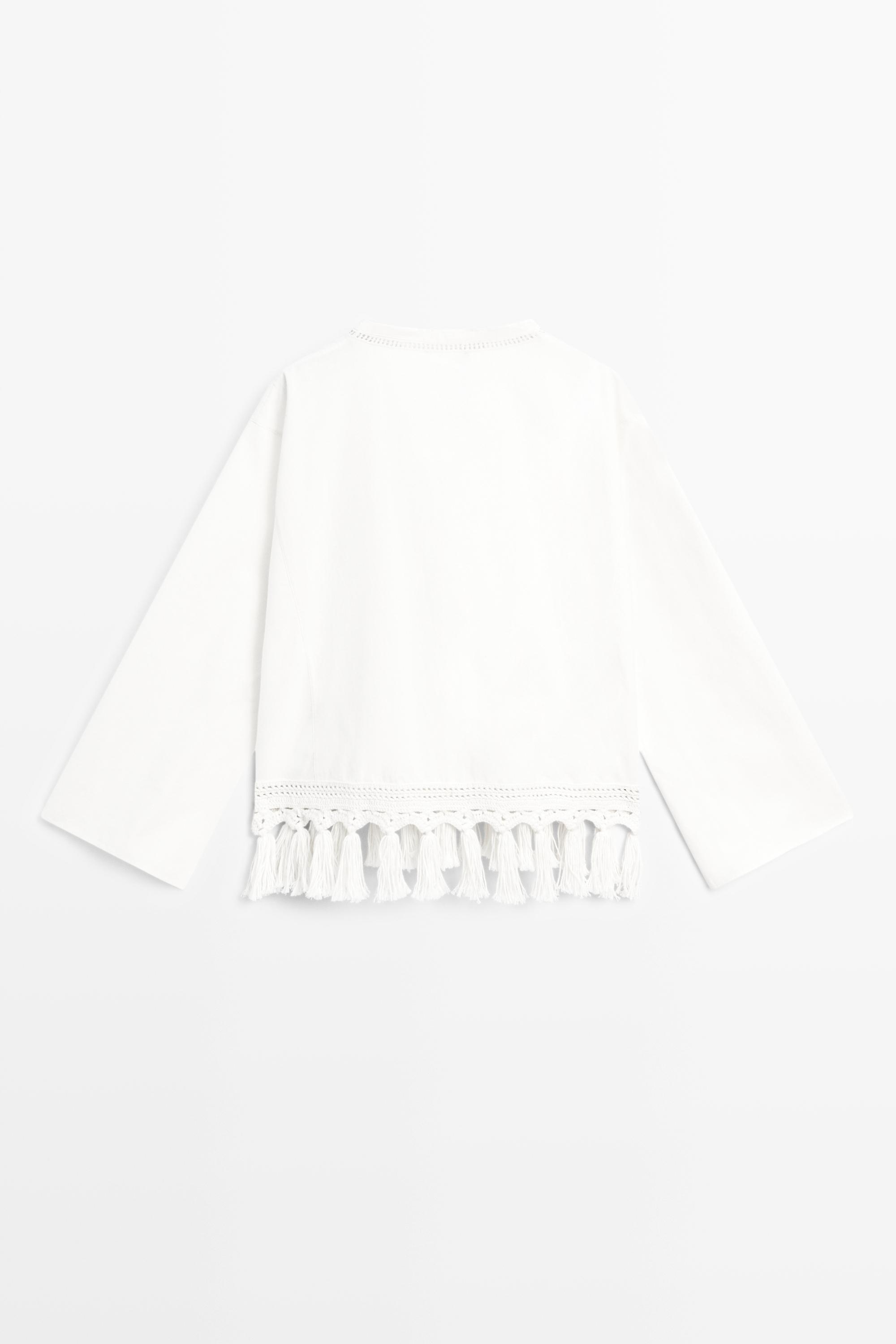 Embroidered blouse with fringed hem